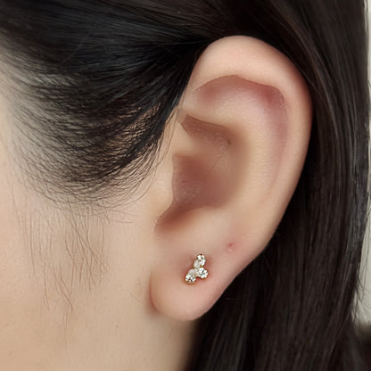 Bloom Stud（ゴールド）を耳たぶにつけた着用イメージ。雫のかたちの石が三つ。チタン フラットバックピアス｜Rozea