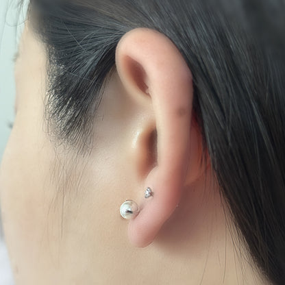 Pure Stud と Luna Pearl（ともにシルバー）を耳たぶに二つ並べて重ねづけした着用イメージ。チタン フラットバックピアス｜Rozea