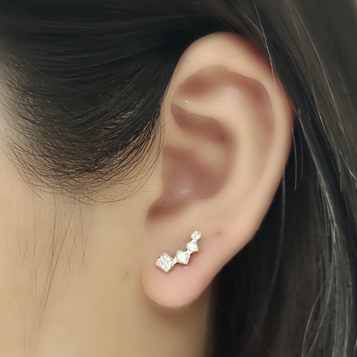Linea Stud（シルバー）を左耳につけた着用イメージ。角のある石が耳の縁に沿って流れる。ペアは同じ形が2個。チタン フラットバックピアス｜Rozea