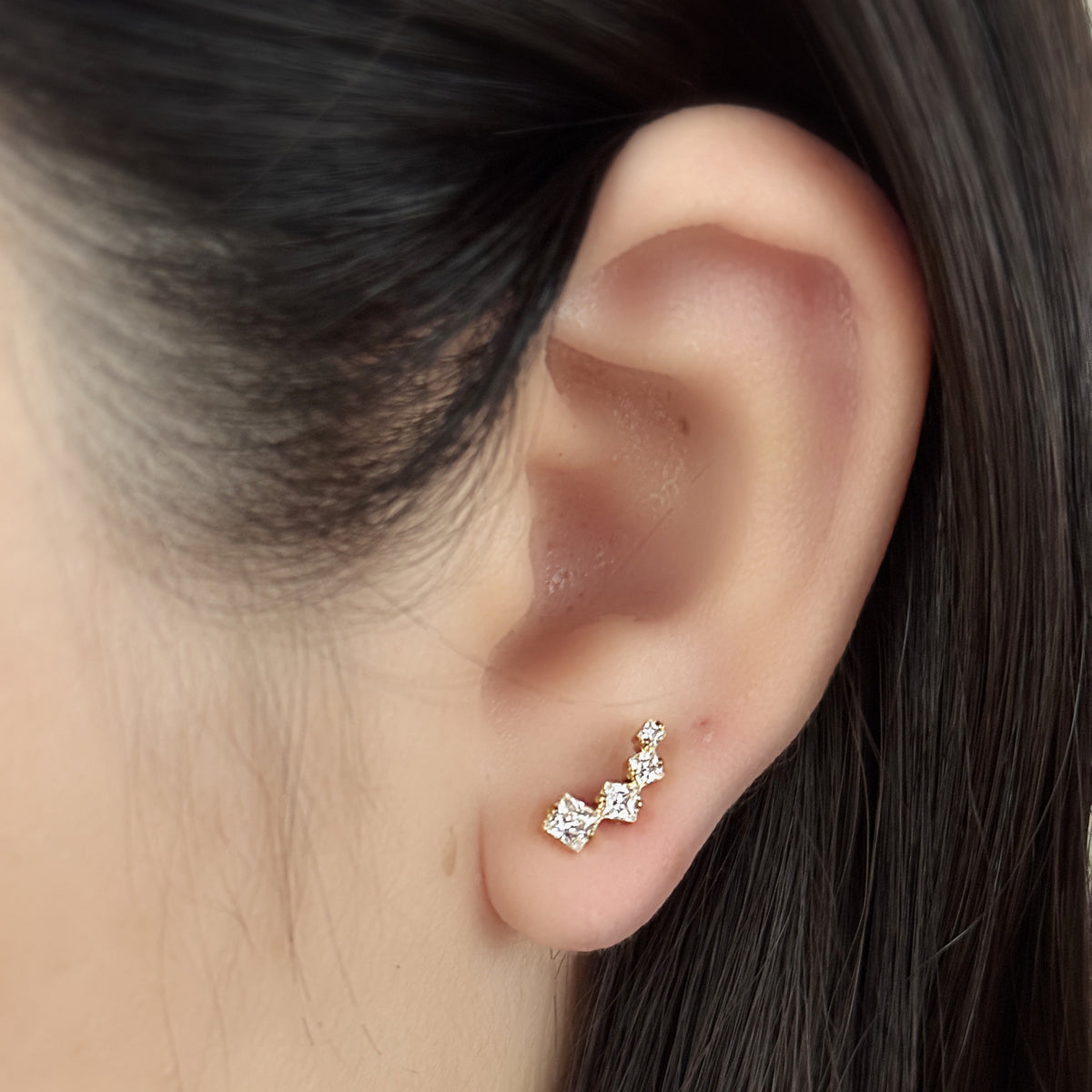 Linea Stud（ゴールド）を耳たぶにつけた着用イメージ。角のある石の弧。チタン フラットバックピアス｜Rozea