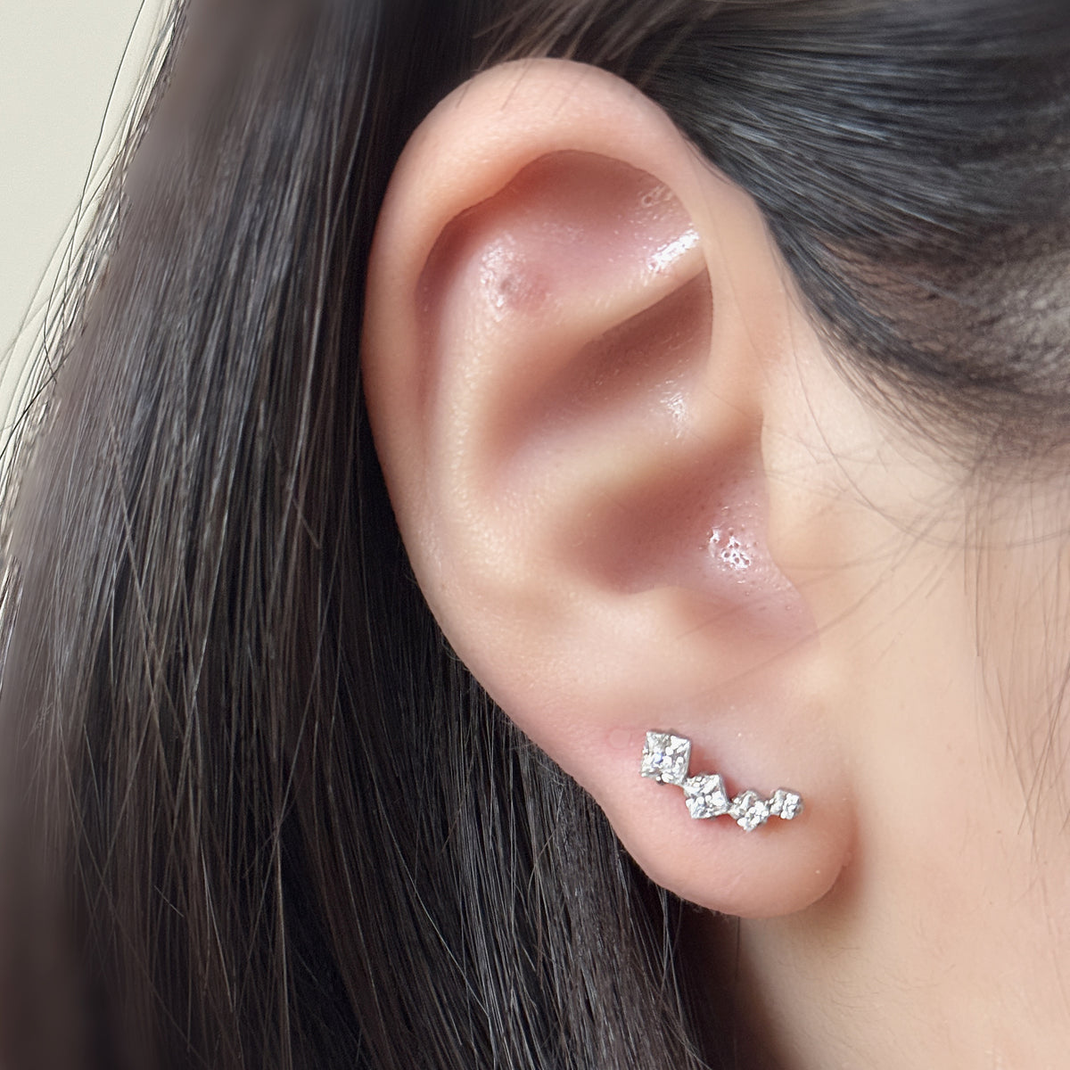 Linea Stud（シルバー）を右耳につけた着用イメージ。左耳とは石の流れる向きが変わります。ペアは同じ形が2個。チタン フラットバックピアス｜Rozea