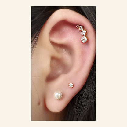Linea Stud（ゴールド）をヘリックスにつけた着用イメージ。角のある石が耳の縁に沿う。チタン フラットバックピアス｜Rozea
