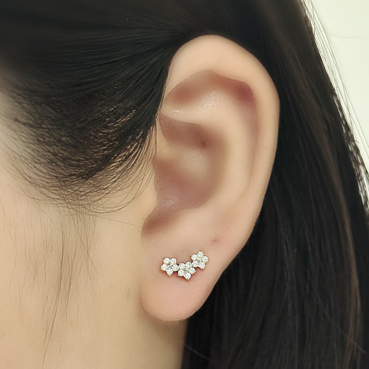 Stella Stud（シルバー）を耳たぶにつけた着用イメージ。小さな星のモチーフ。チタン フラットバックピアス｜Rozea
