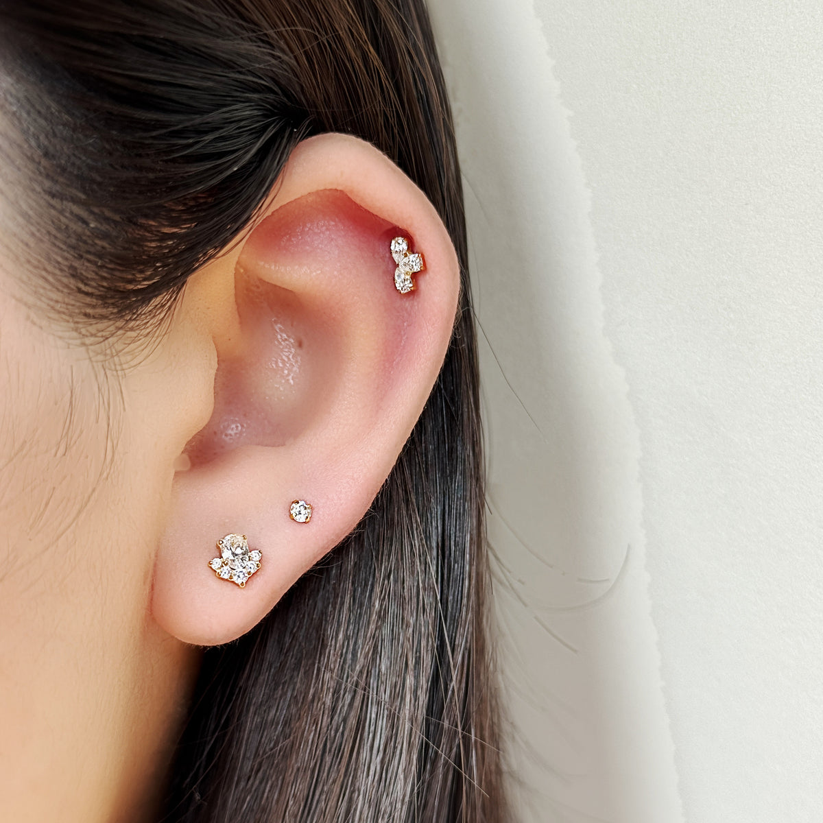 Veil Stud（ゴールド）を耳たぶにつけた着用イメージ。チタン フラットバックピアス｜Rozea